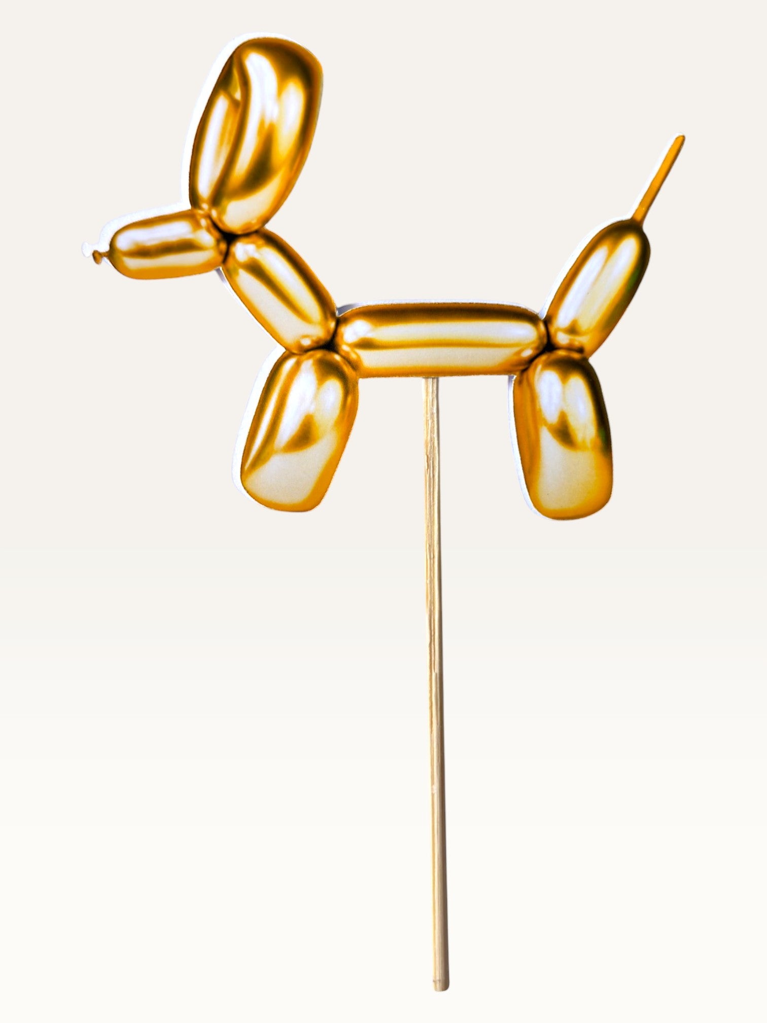 Paper Party Studio gold metallic balloon dog cake topper made of thick paper on a bamboo stick
