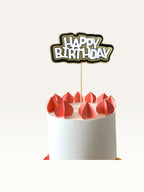 Paper Party Studio layered Happy Birthday cake topper with white block letters and gold scalloped backing on a pick.