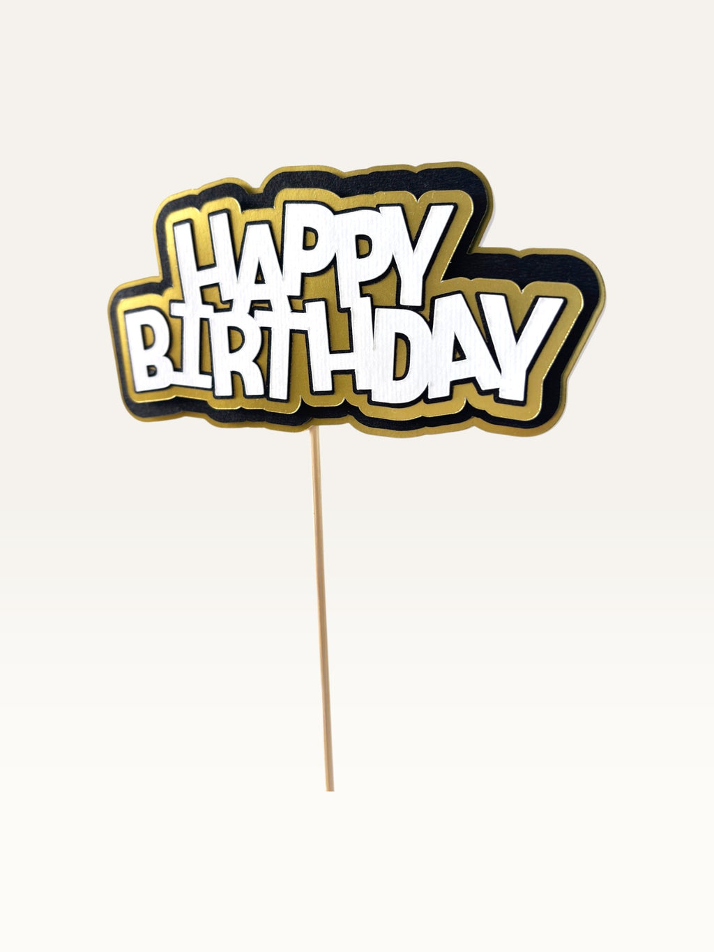 Paper Party Studio layered Happy Birthday cake topper with white lettering, black outline, and gold scalloped edge.