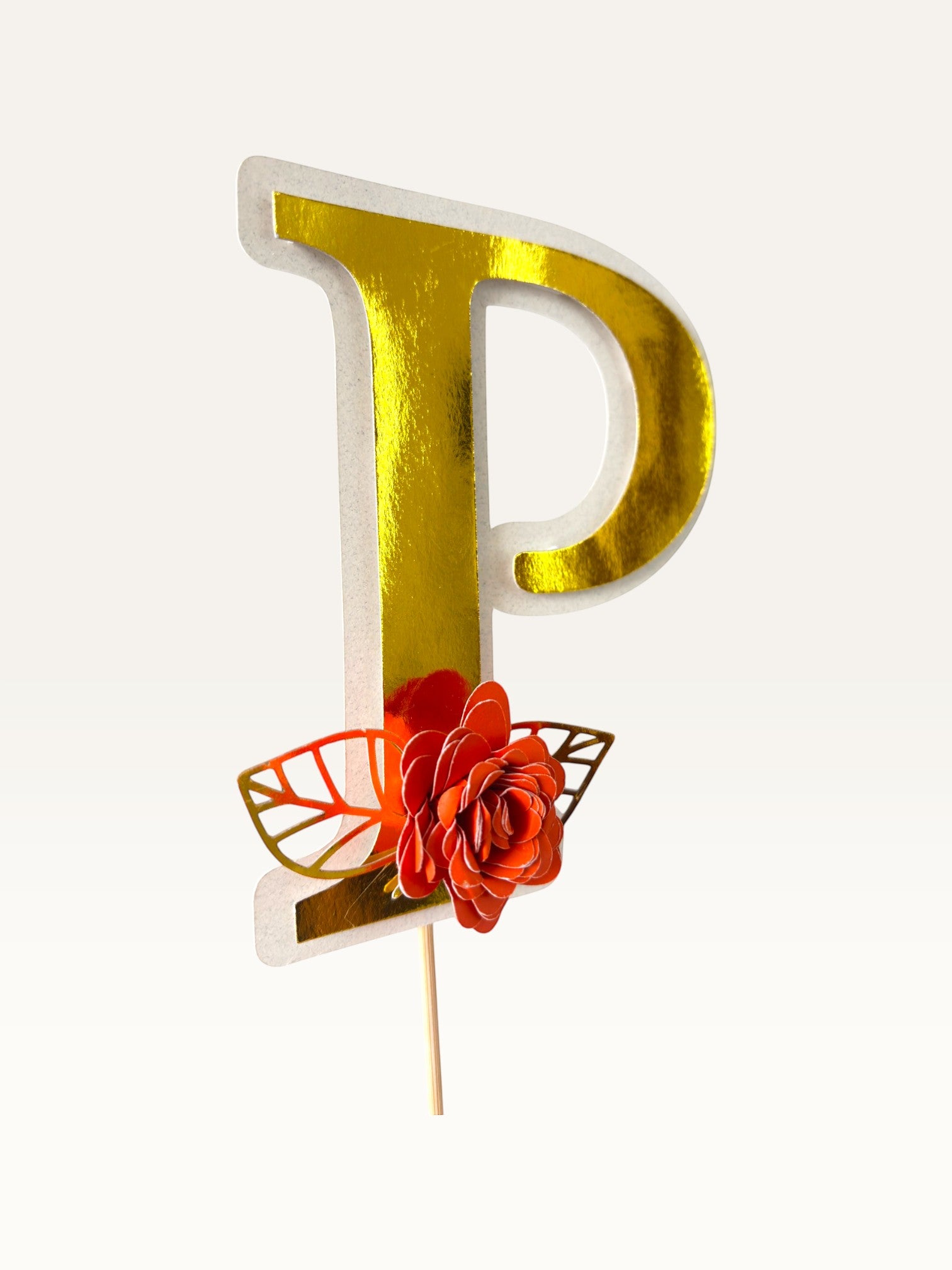 Paper Party Studio personalised gold foil letter P cake topper with a handmade orange paper flower and foil leaf.