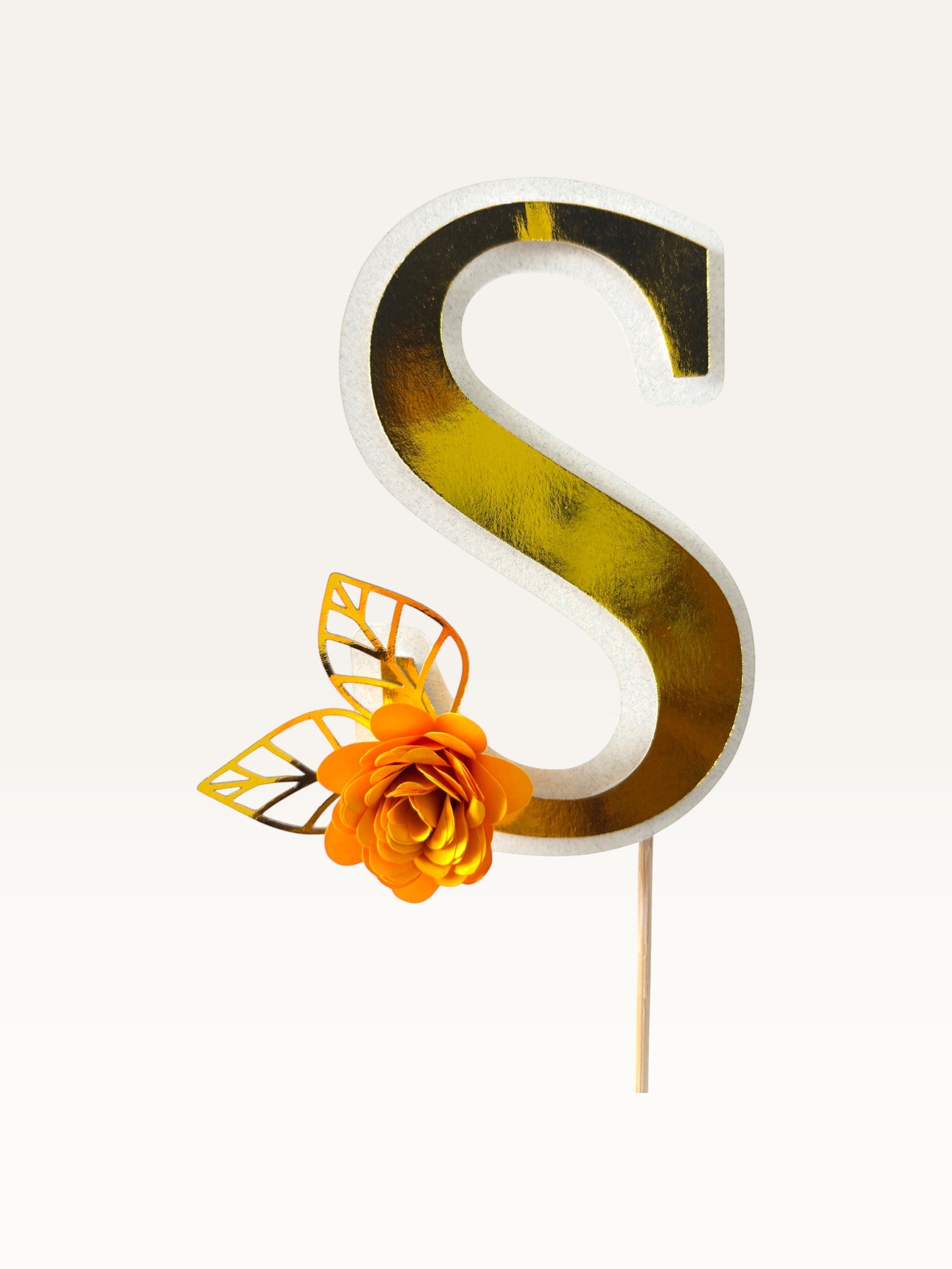 Paper Party Studio personalised gold foil letter S cake topper with an orange paper flower and gold leaf on a pick