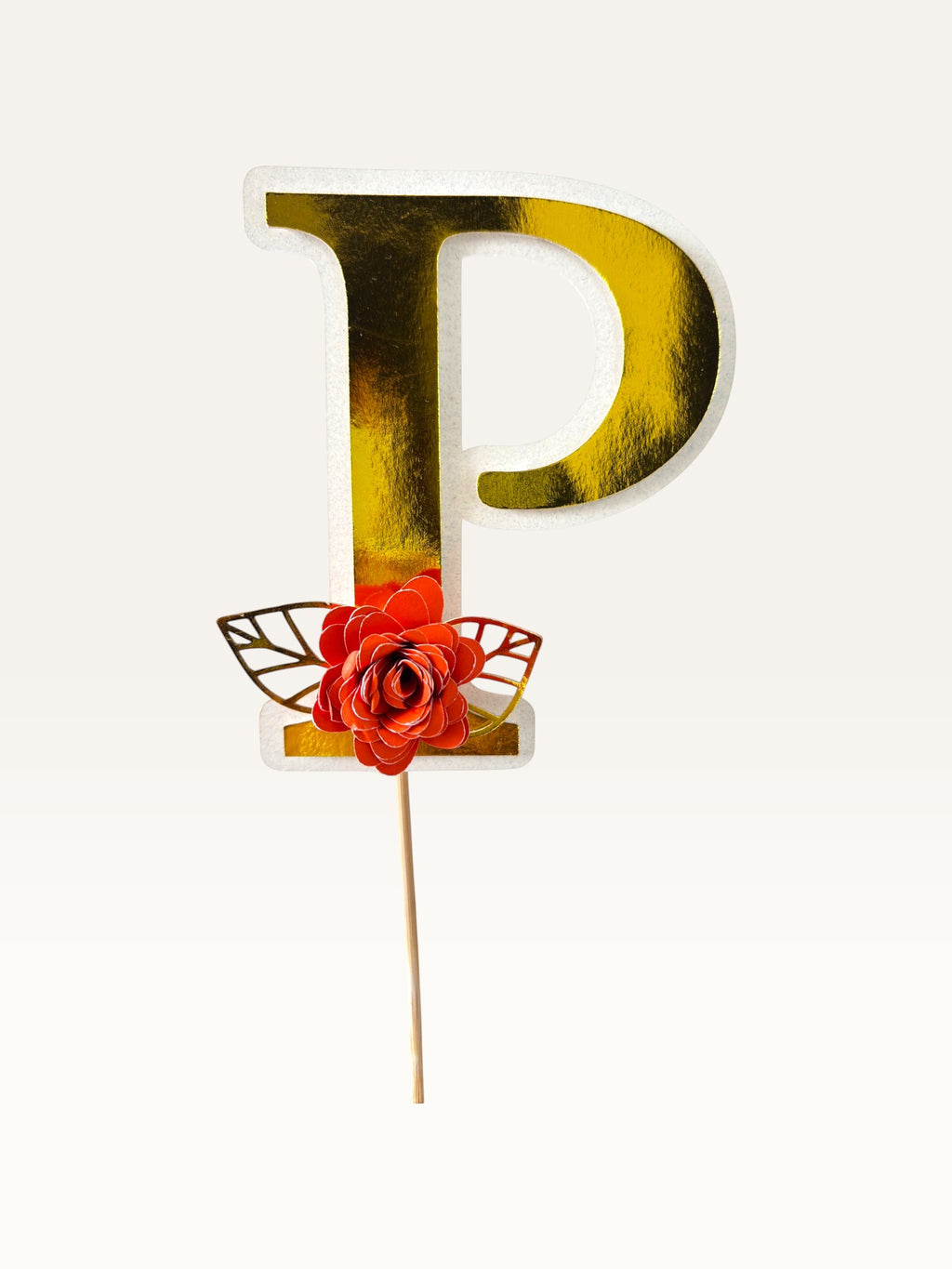 Paper Party Studio personalised gold foil letter P cake topper with a red paper flower and gold leaf on a wooden pick