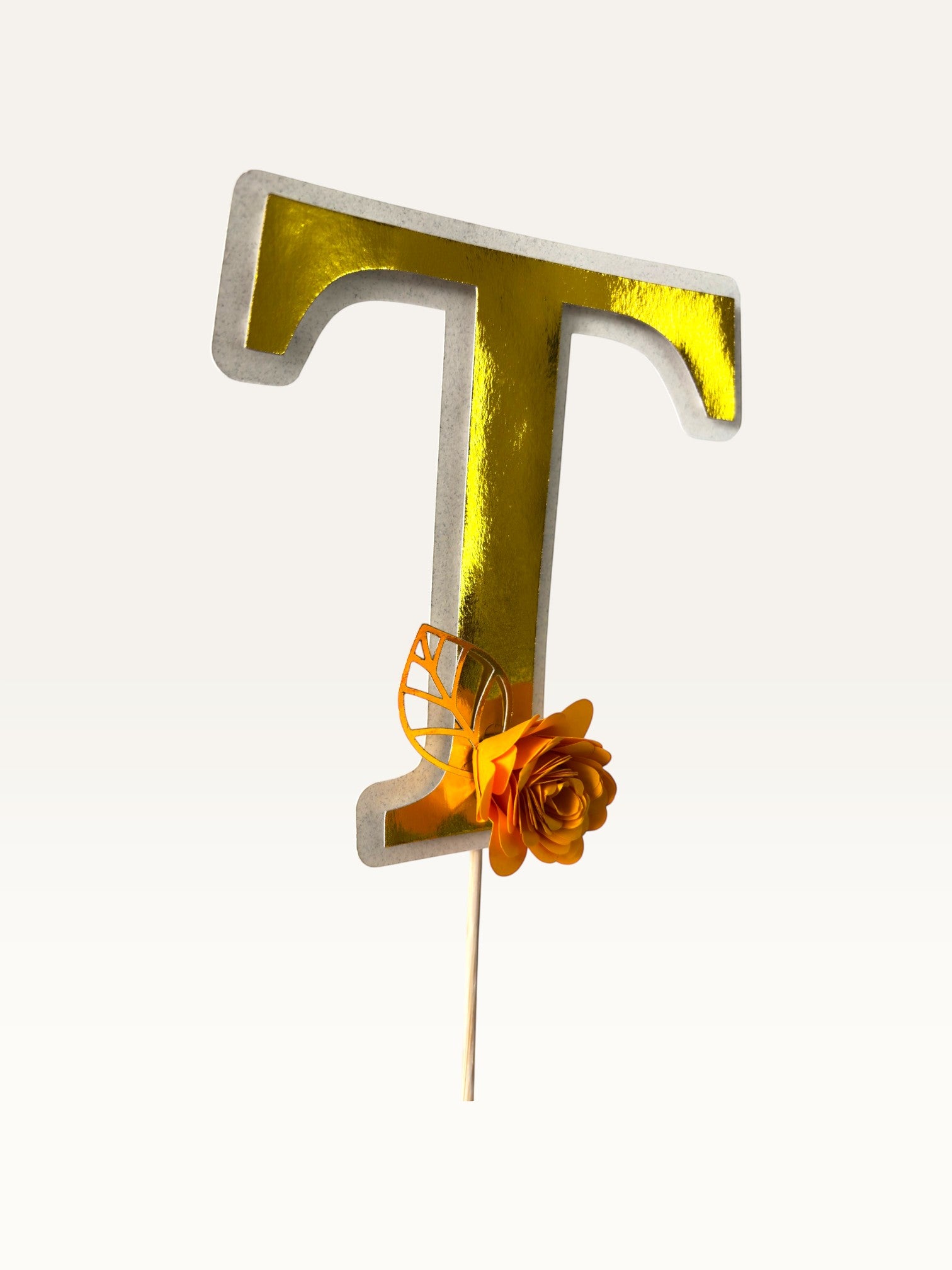 Paper Party Studio personalised gold foil letter T cake topper with a handmade orange paper flower and foil leaf.