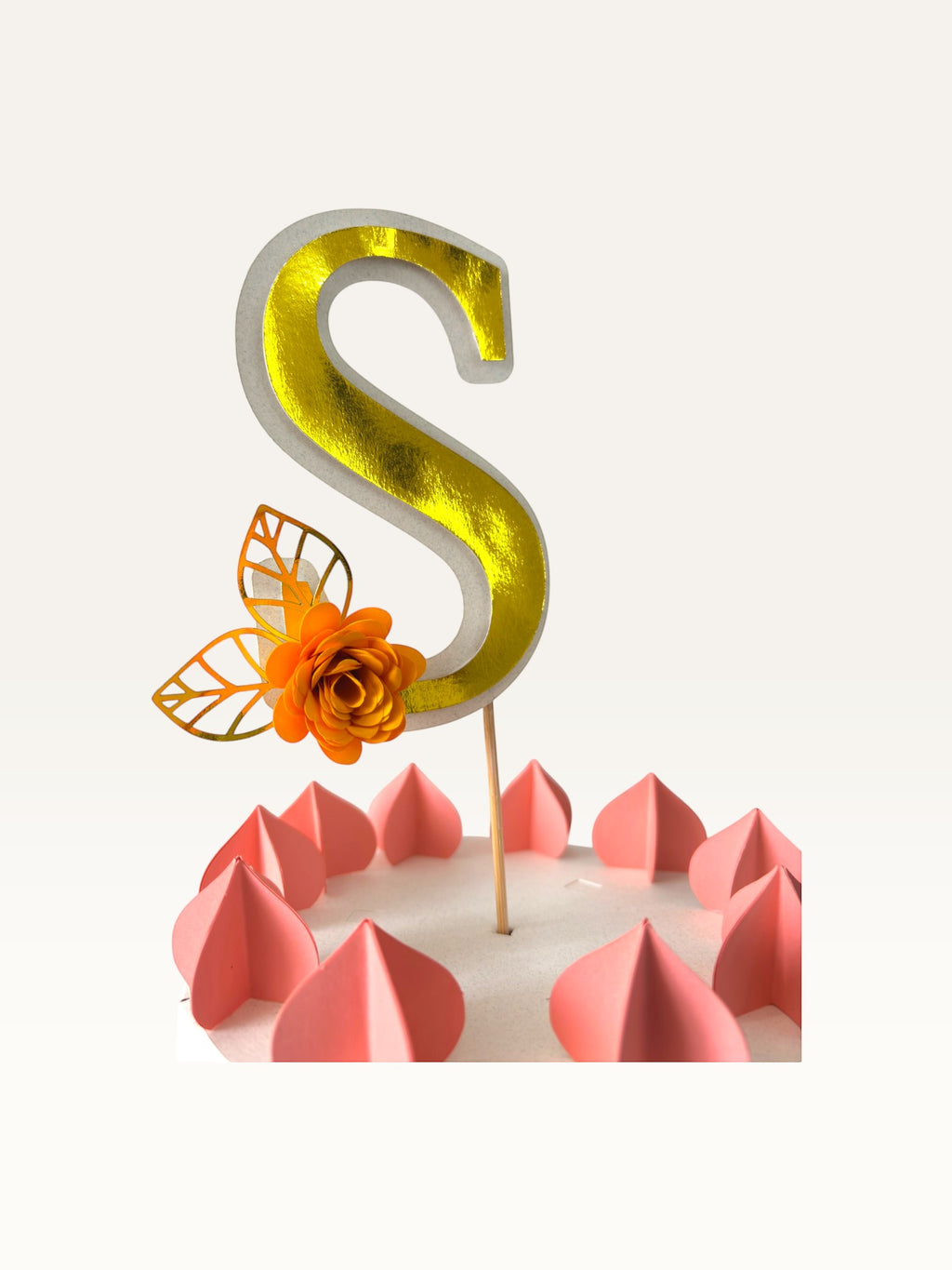 Paper Party Studio personalised gold foil letter S cake topper with an orange paper flower on a wooden pick