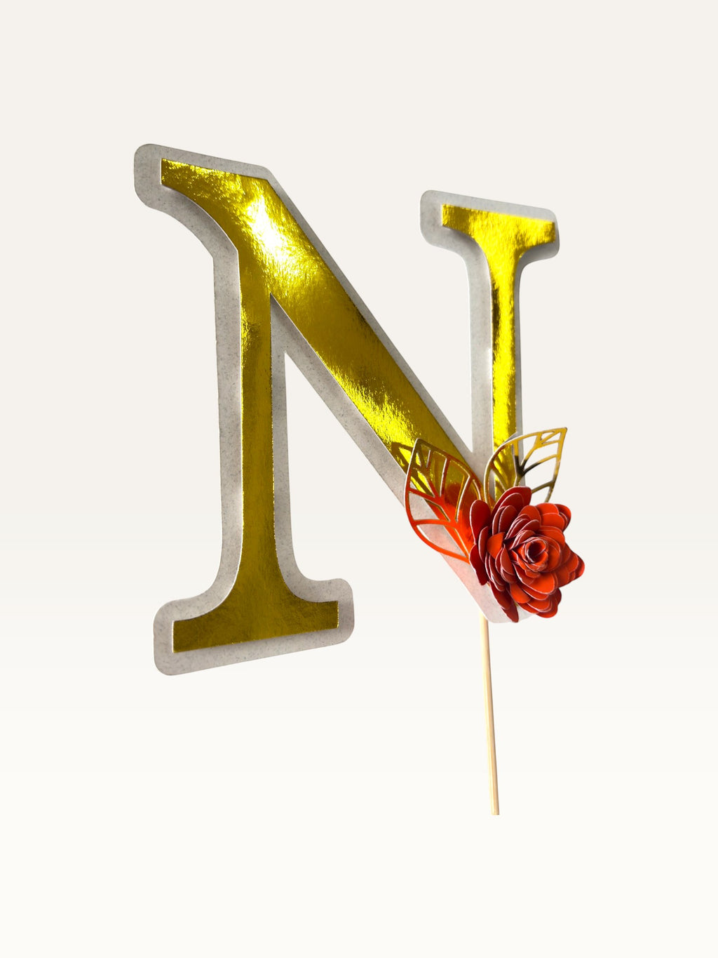 Paper Party Studio personalised gold foil letter N cake topper with a red paper flower and delicate gold leaf detail.