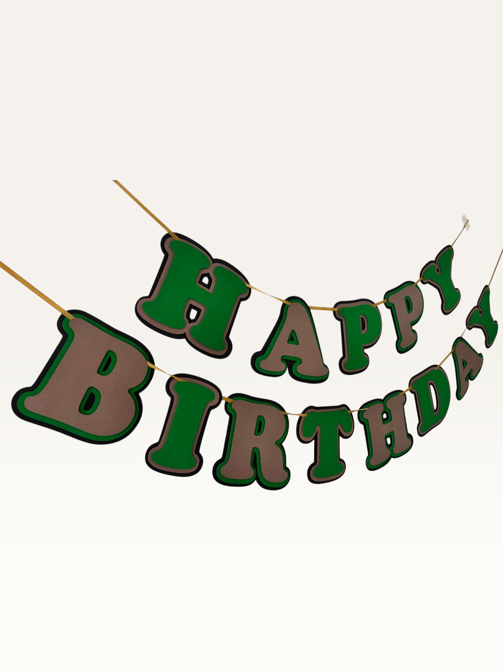 Paper Party Studio layered green and brown Happy Birthday banner with dimensional cut-out letters on a hanging cord.