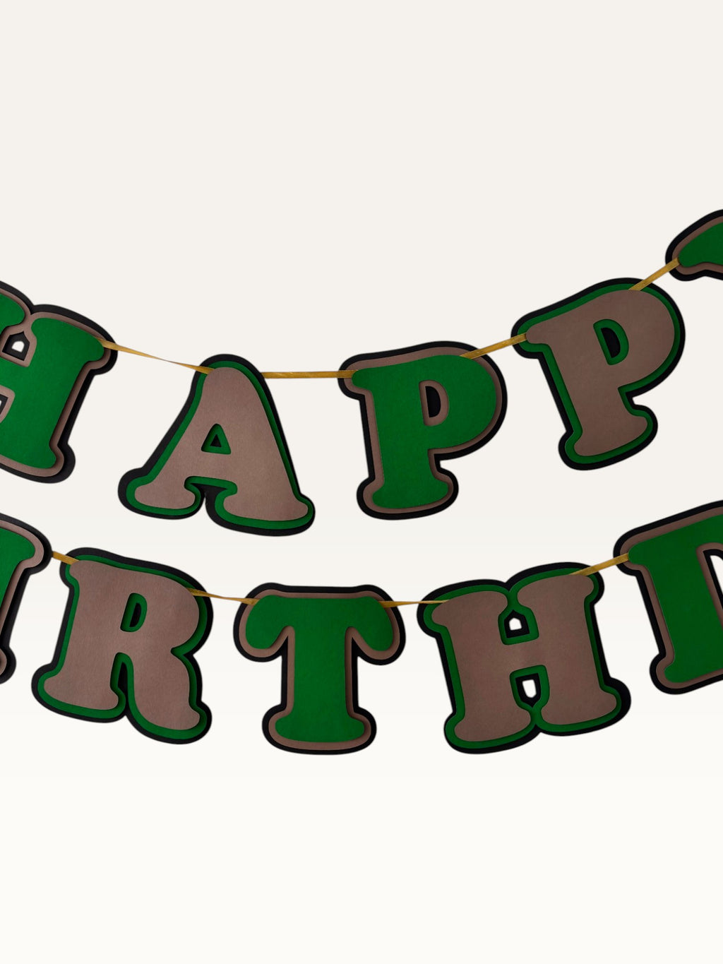 Paper Party Studio layered green and brown Happy Birthday banner with dimensional cut-out letters on a cord.