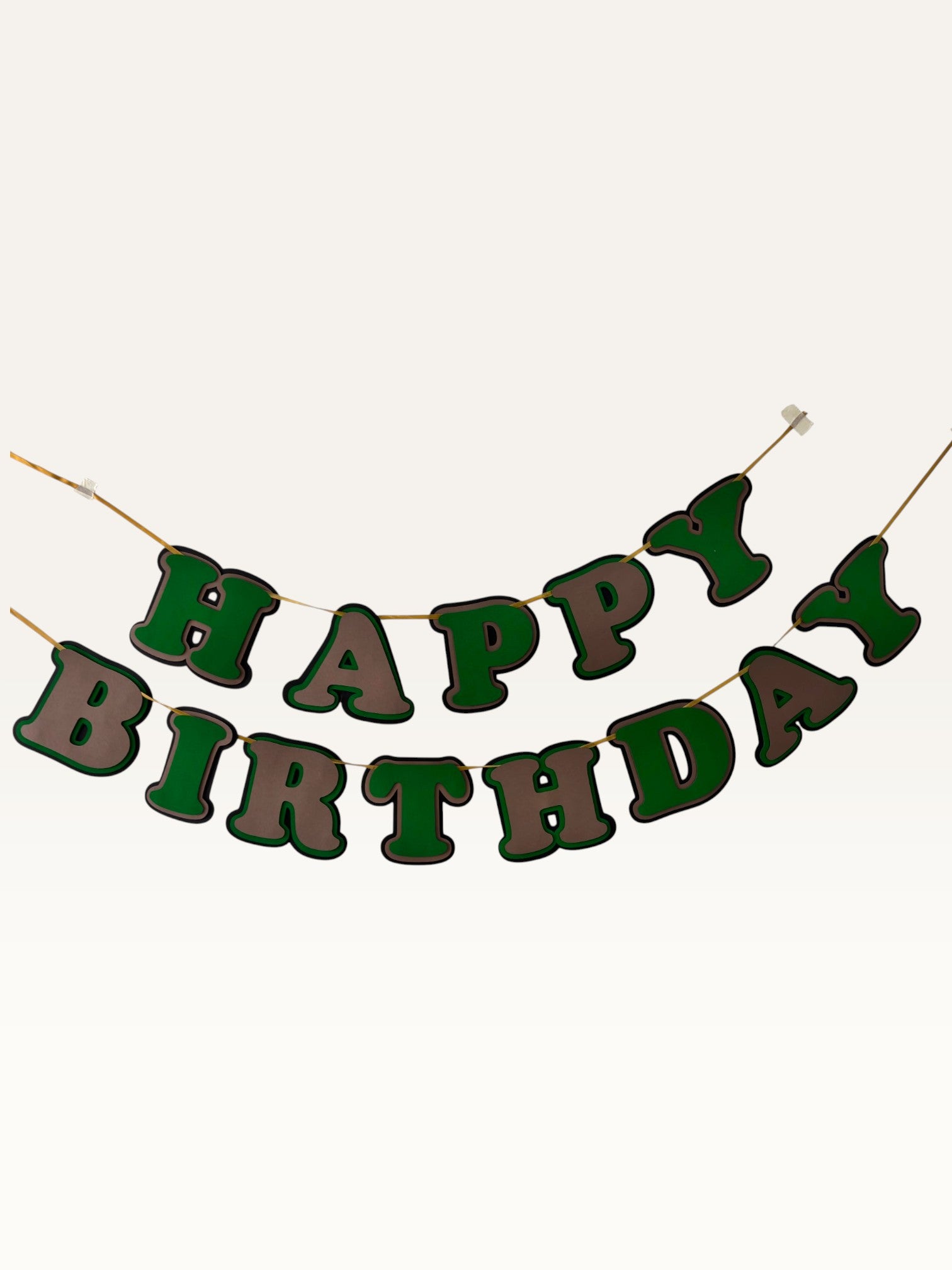 Paper Party Studio layered green and brown Happy Birthday banner with dimensional cut-out letters on a hanging cord.