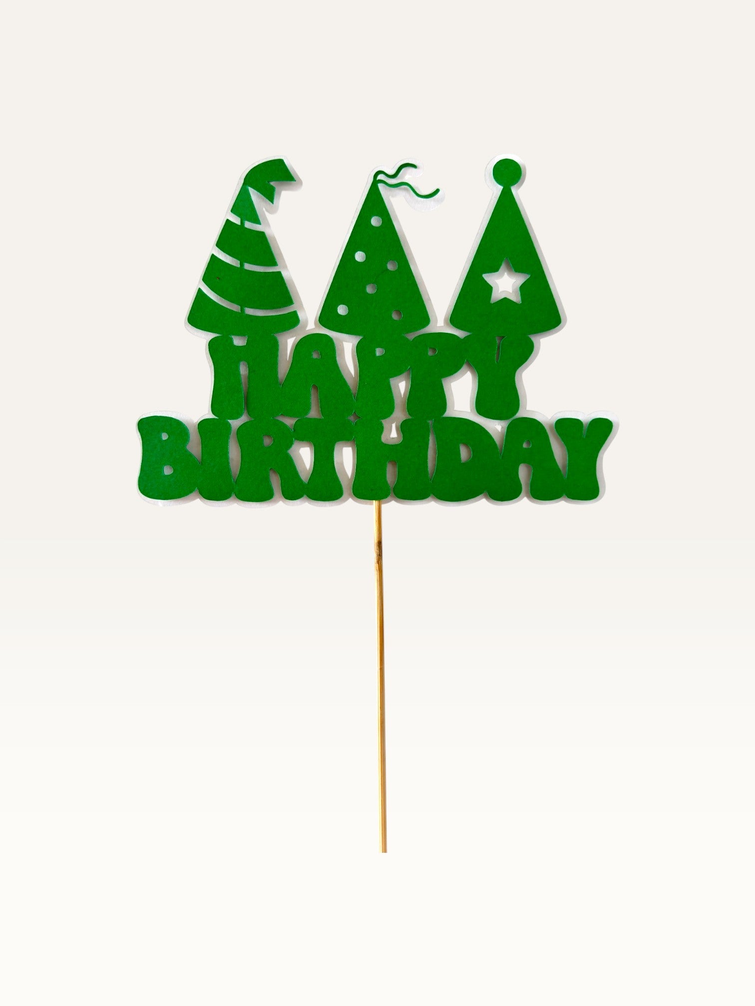 Paper Party Studio green Happy Birthday cake topper with three party hat cut-outs on a wooden pick.