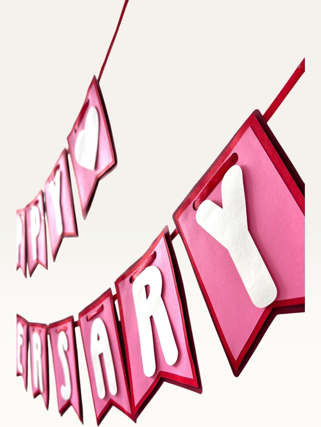 Paper Party Studio Happy Anniversary banner with pink swallowtail cardstock flags and white 3D heart and letter accents