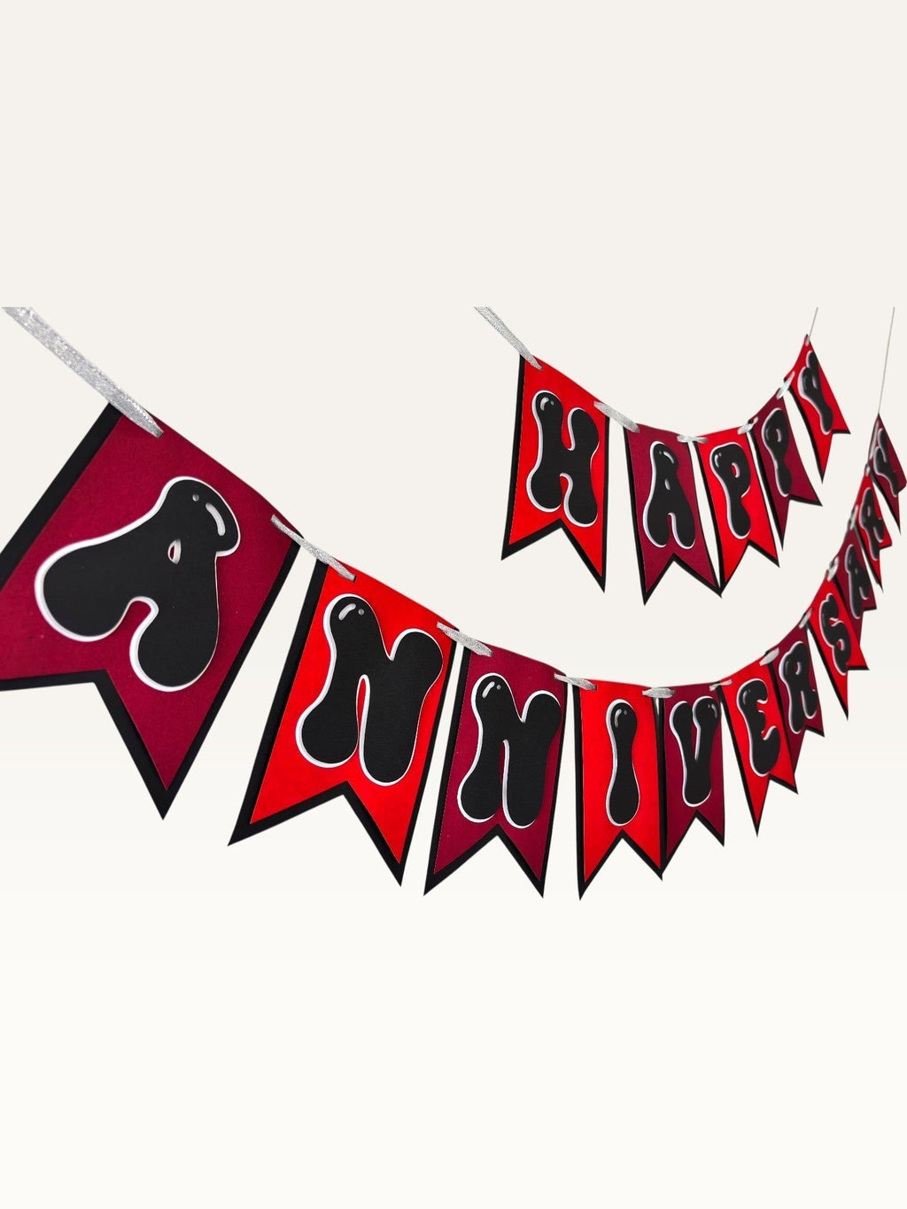 Paper Party Studio Happy Anniversary bunting with red swallowtail flags and black bubble letters on silver string.