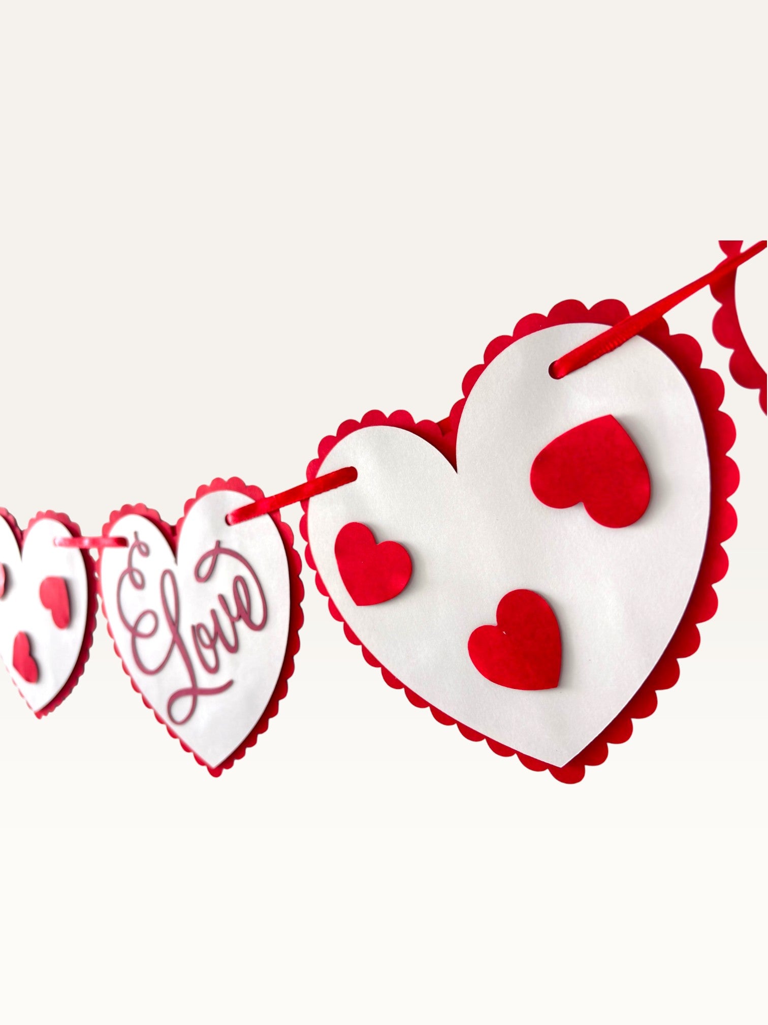 Paper Party Studio romantic heart bunting with scalloped white cardstock hearts and red script on a red cord