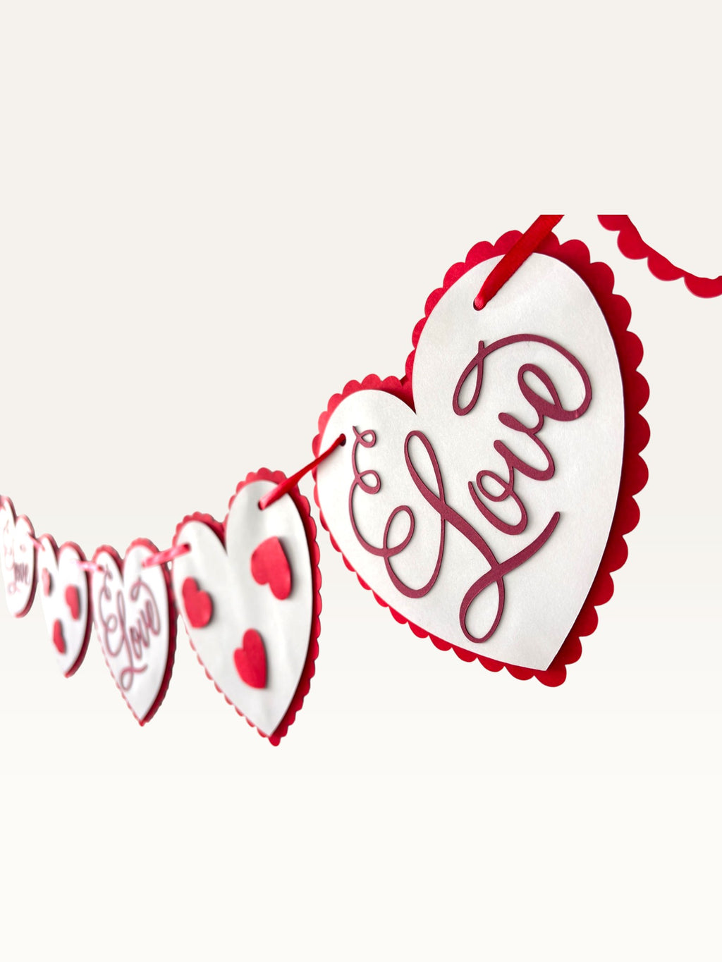 Paper Party Studio romantic heart bunting with scalloped white cardstock hearts on a red cord for Valentine's Day.