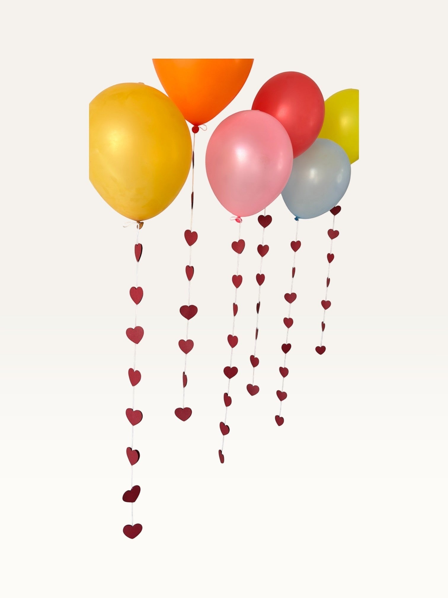 Paper Party Studio heart garland strings hanging from colorful balloons for a romantic wedding or party backdrop.