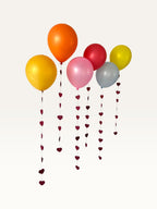Paper Party Studio heart garland strings hanging from colorful balloons for a romantic wedding or event backdrop.