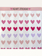 Paper Party Studio glossy heart sticker sheet with rows of pink, red, and lilac hearts on a striped background.