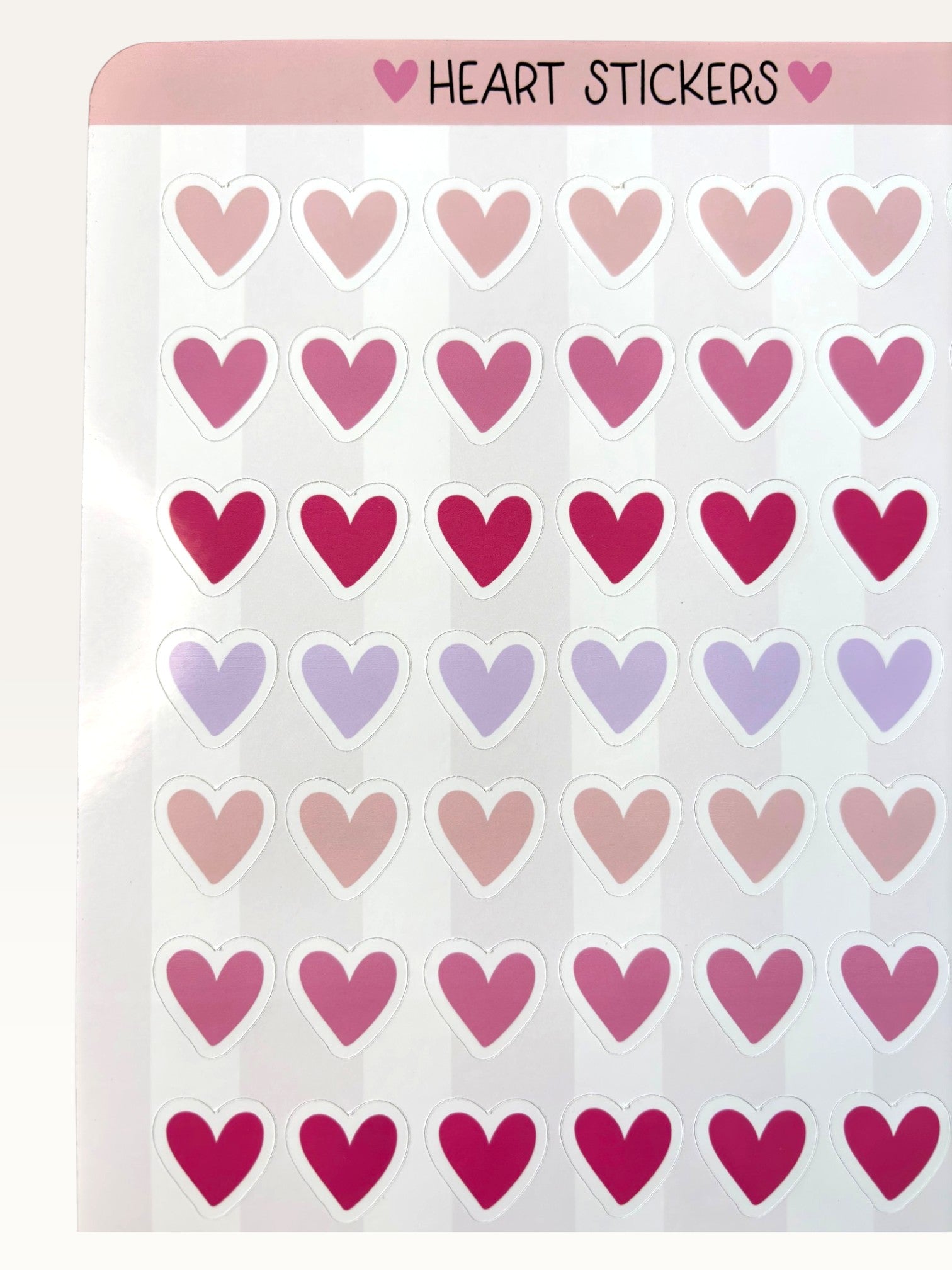 Paper Party Studio heart sticker sheet featuring rows of glossy pink, red, and lilac heart stickers on a white sheet.