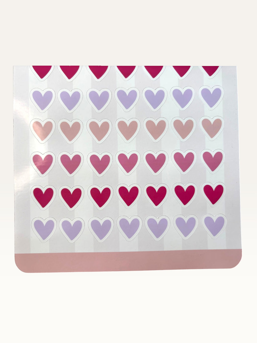 Paper Party Studio heart sticker sheet with rows of glossy pink, red, and lilac heart stickers on a striped background.