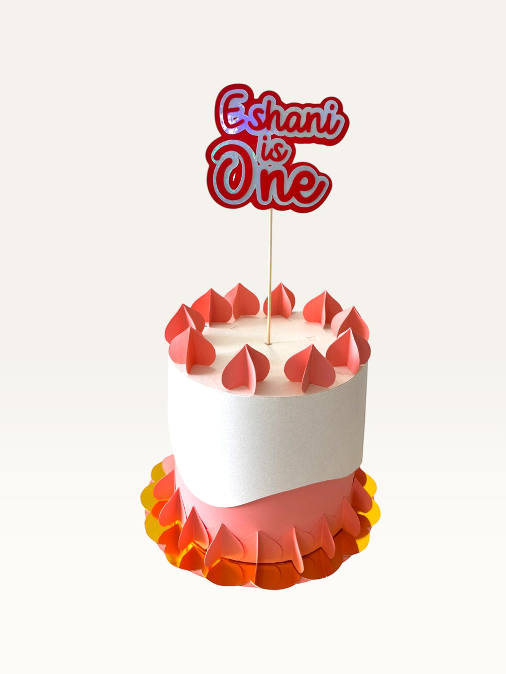 Paper Party Studio personalised holographic script cake topper reading Eshani is One on a decorative birthday cake