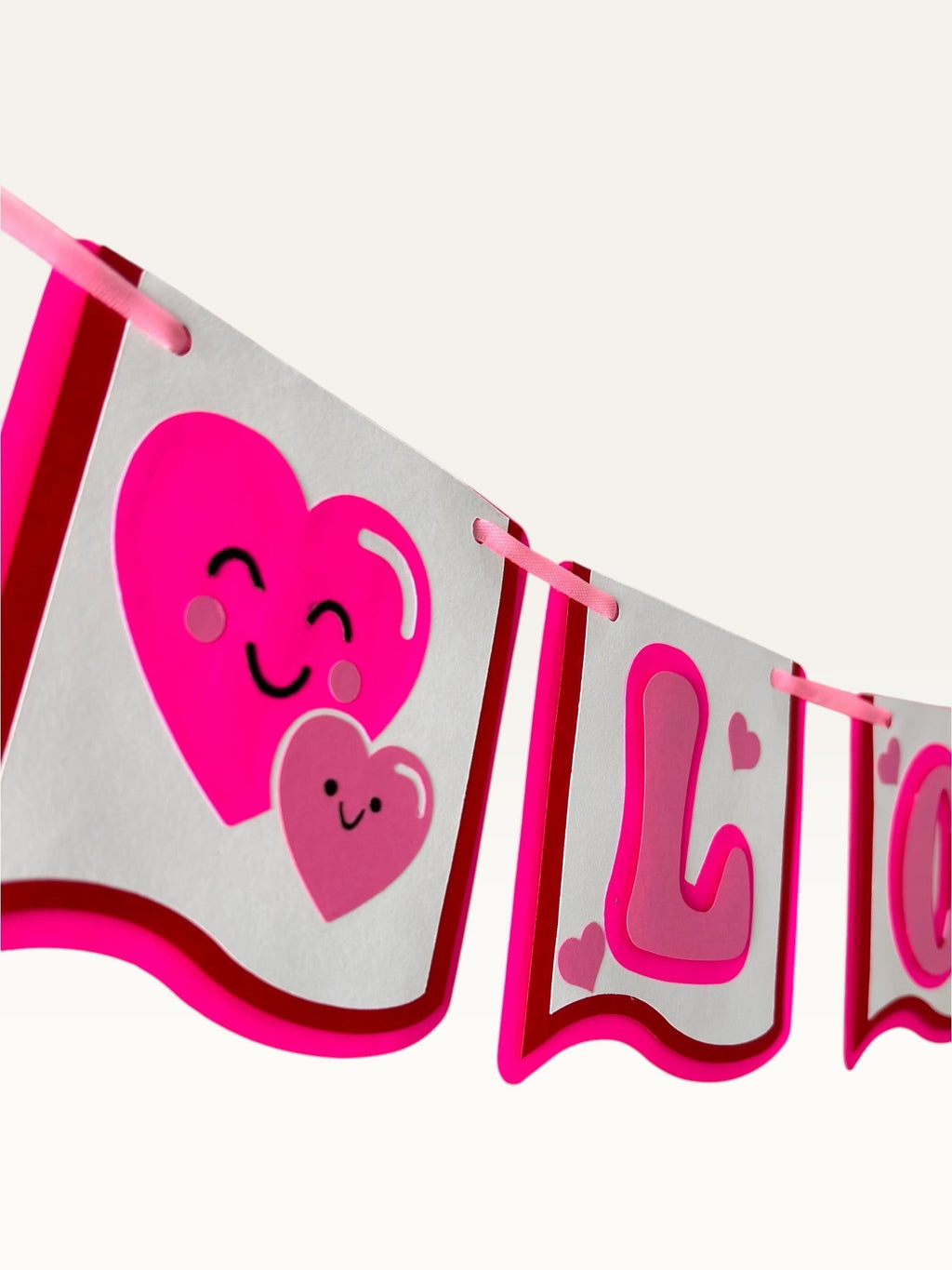 Paper Party Studio handmade I Love You banner with pink heart characters on white cardstock for romantic decor.