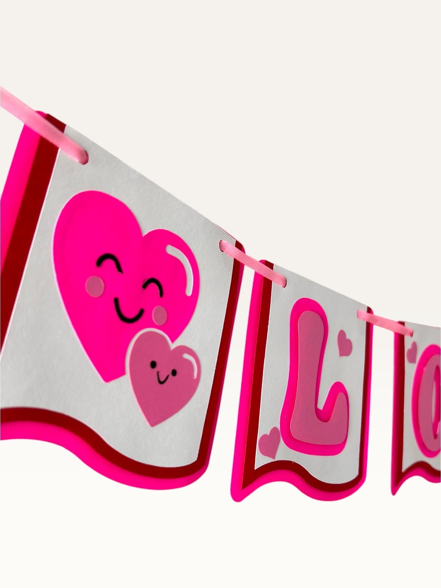 Paper Party Studio handmade I Love You banner with pink heart characters on white cardstock for romantic decor.
