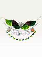Paper Party Studio jungle safari birthday banner set with green paper fans, animal flags spelling FOUR, and garland.