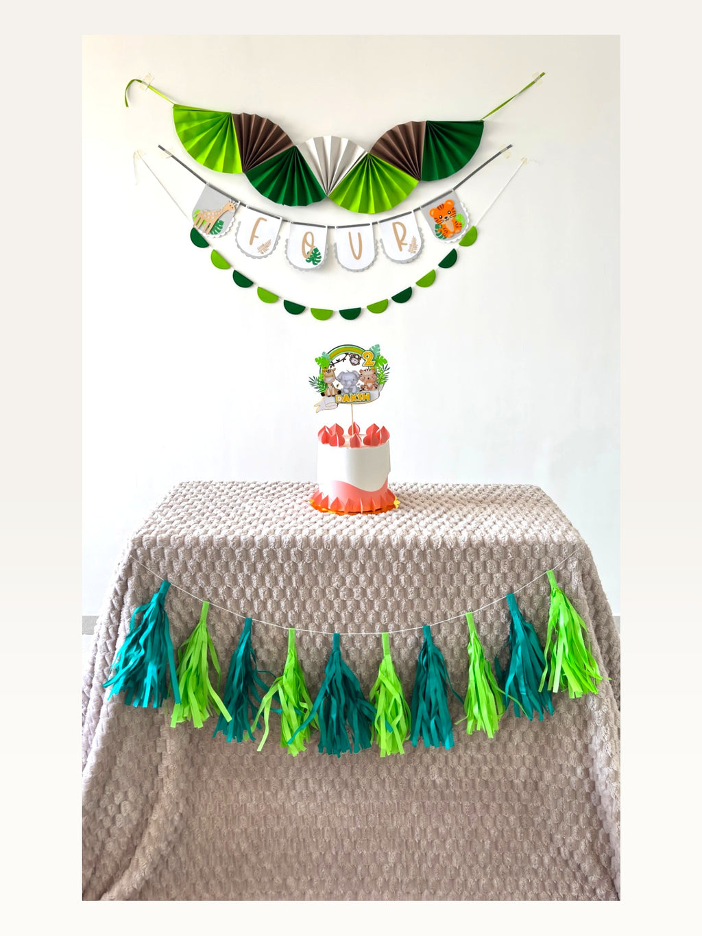 Paper Party Studio jungle safari birthday decoration set with personalised banner, cake topper, and paper tassels.