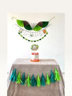 Paper Party Studio jungle safari birthday decoration set with personalised banner, cake topper, and paper tassels.