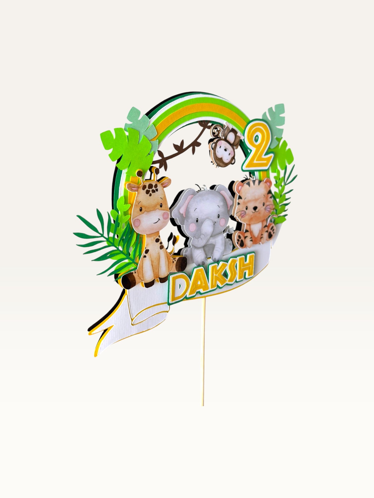 Paper Party Studio personalised jungle safari cake topper with giraffe, elephant, tiger, and monkey on a green wreath.