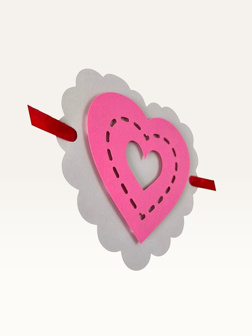 Paper Party Studio layered heart garland with scalloped white and pink cardstock hearts featuring stitched details.