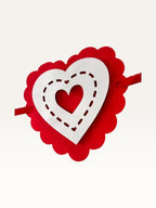 Paper Party Studio layered heart garland featuring red scalloped cardstock hearts with white stitched-effect details.