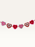 Paper Party Studio layered heart garland with pink, red, and white scalloped cardstock hearts and stitched details.