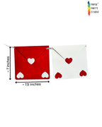 Paper Party Studio red and white envelope bunting with heart cut-outs on a silver cord for Valentine's Day decor.