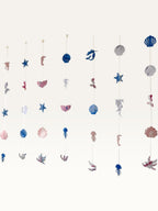 Paper Party Studio under the sea hanging backdrop with pink and blue cardstock mermaid, shell, and starfish shapes.