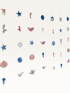 Paper Party Studio under the sea hanging backdrop with pink and blue mermaid, shell, and starfish cardstock cutouts.