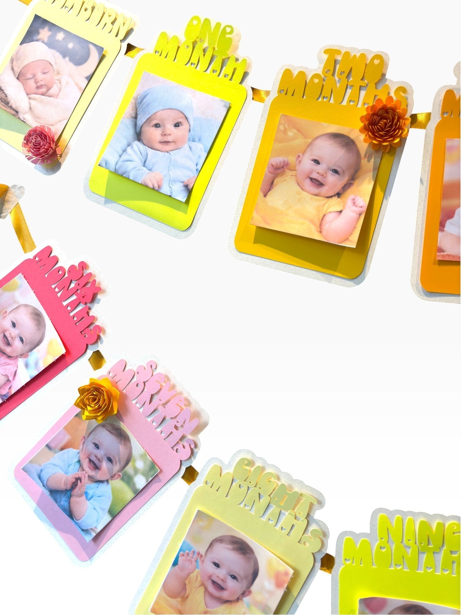 Paper Party Studio monthly milestone photo banner with 13 frames in sunset colors, each with a paper rosette accent.
