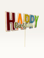 Paper Party Studio handmade multicolour block letter Happy Birthday cake topper with gold script and white outline.