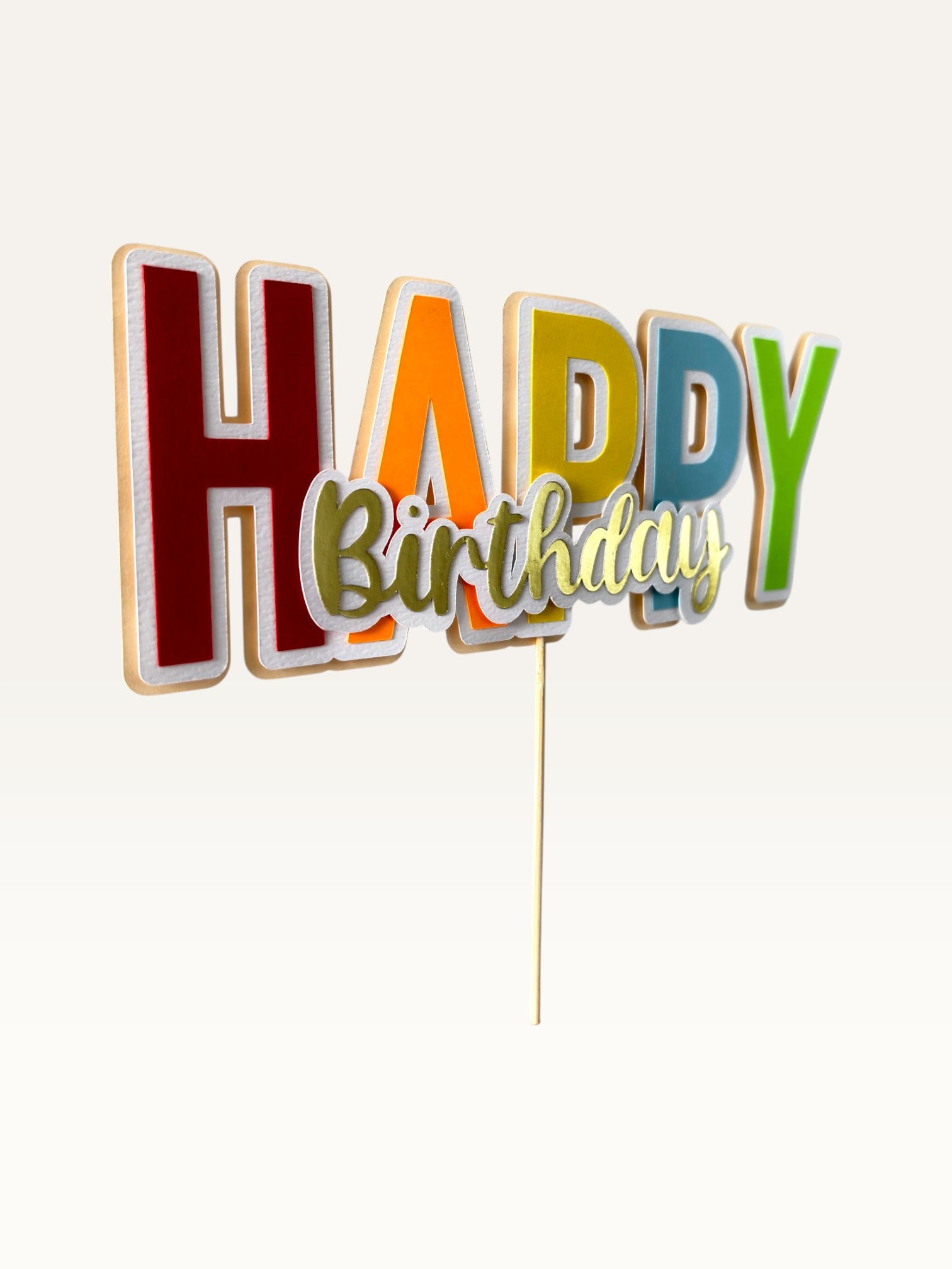 Paper Party Studio handmade multicolour block letter Happy Birthday cake topper with gold script and white outline.