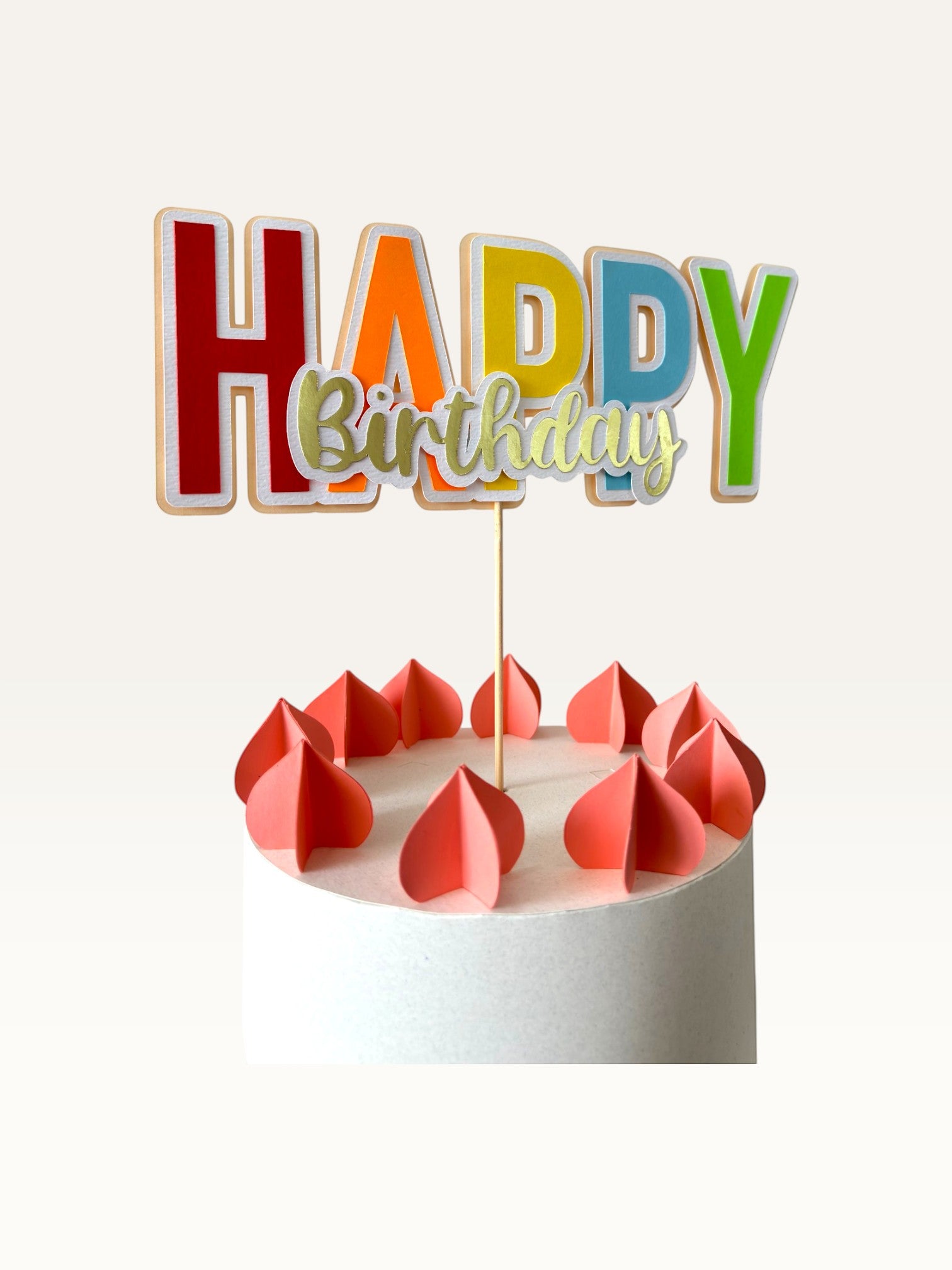 Paper Party Studio multicolour Happy Birthday cake topper with gold script lettering on a white cake