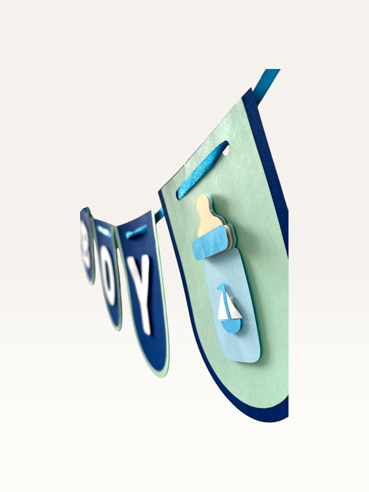 Paper Party Studio navy and sage cardstock baby boy banner with milk bottle cut-out detail for baby shower decor.