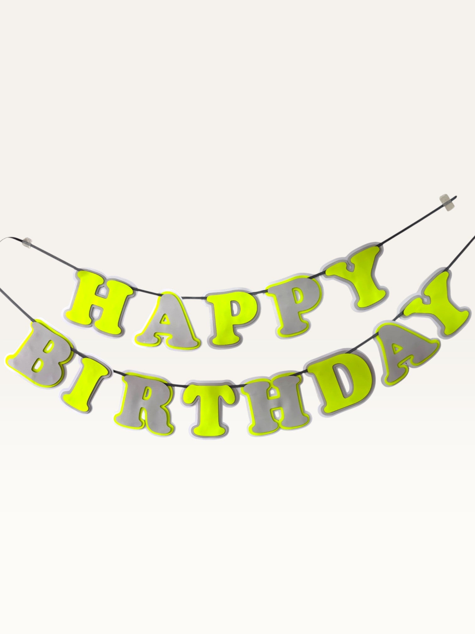 Paper Party Studio neon yellow and grey layered paper Happy Birthday banner strung on a black cord.