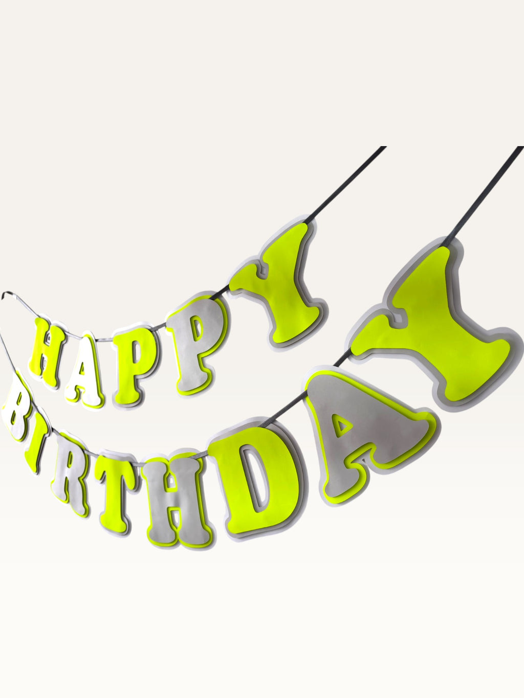 Paper Party Studio neon yellow and grey layered paper Happy Birthday banner strung on a cord for party decoration.