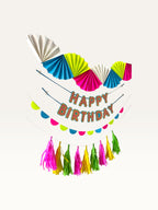 Paper Party Studio neon candy birthday decoration set with paper fans, Happy Birthday banner, and tassel garland.