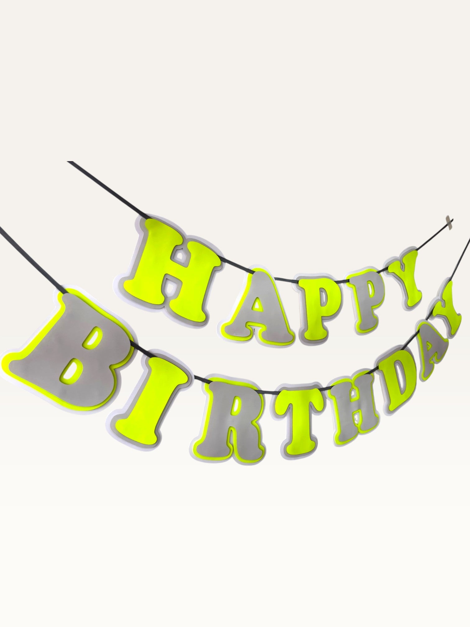 Paper Party Studio neon and grey layered paper Happy Birthday banner with bold cut-out letters on a hanging cord.