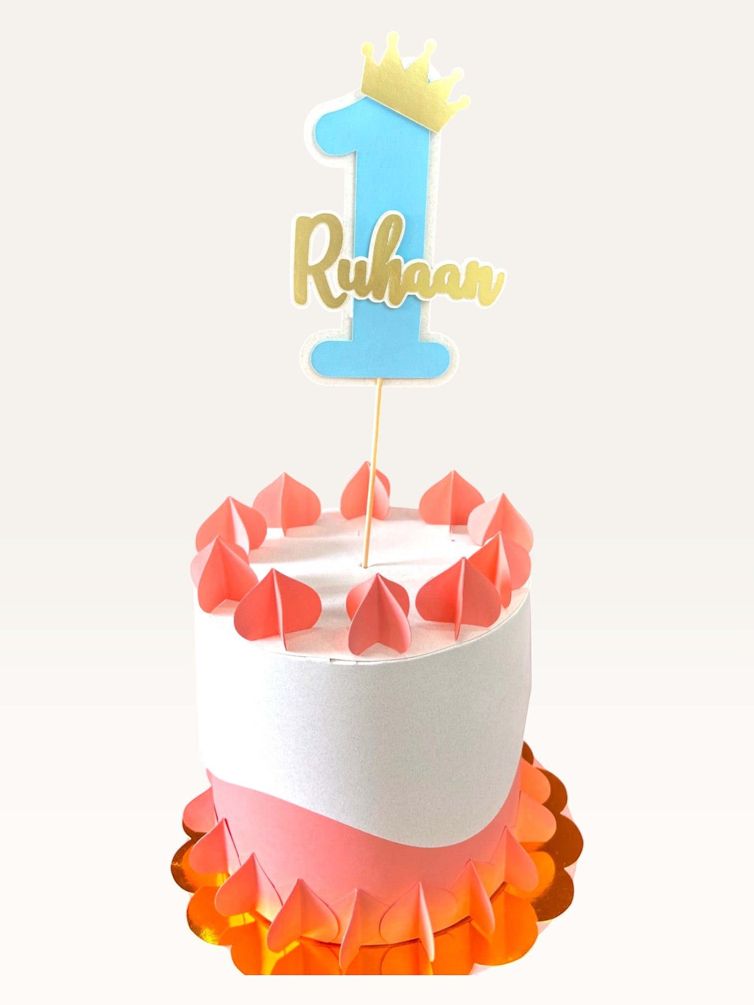 Paper Party Studio personalized blue number one cake topper with a gold crown and name on a decorated cake