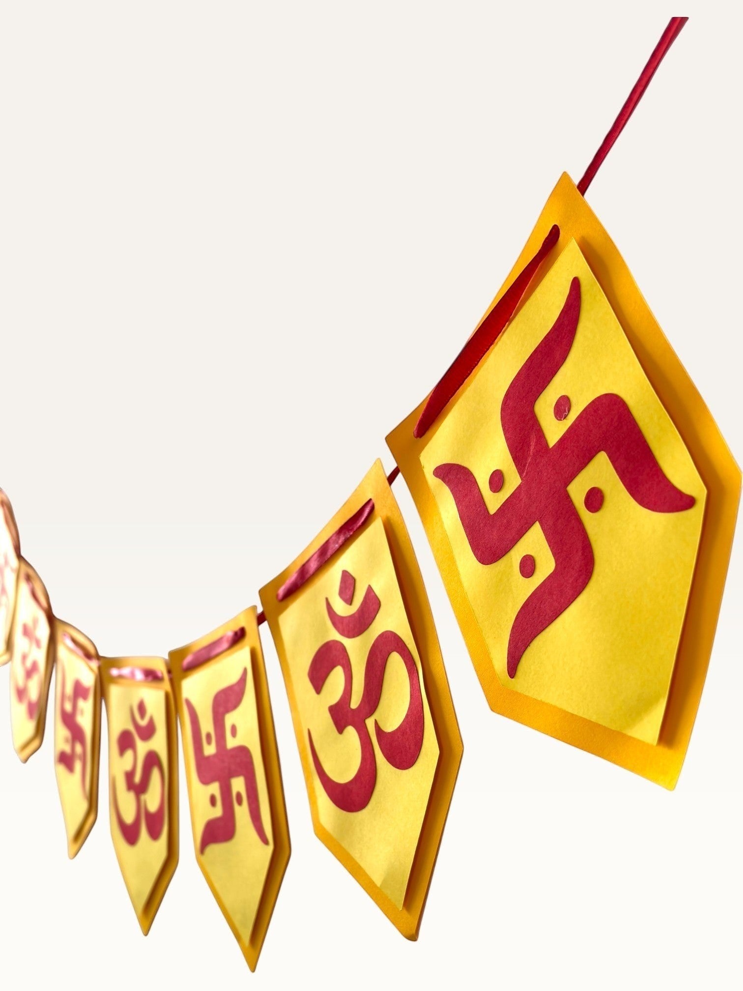 Paper Party Studio yellow and red cardstock bunting with Om and Swastik symbols for Diwali and festive home decor.