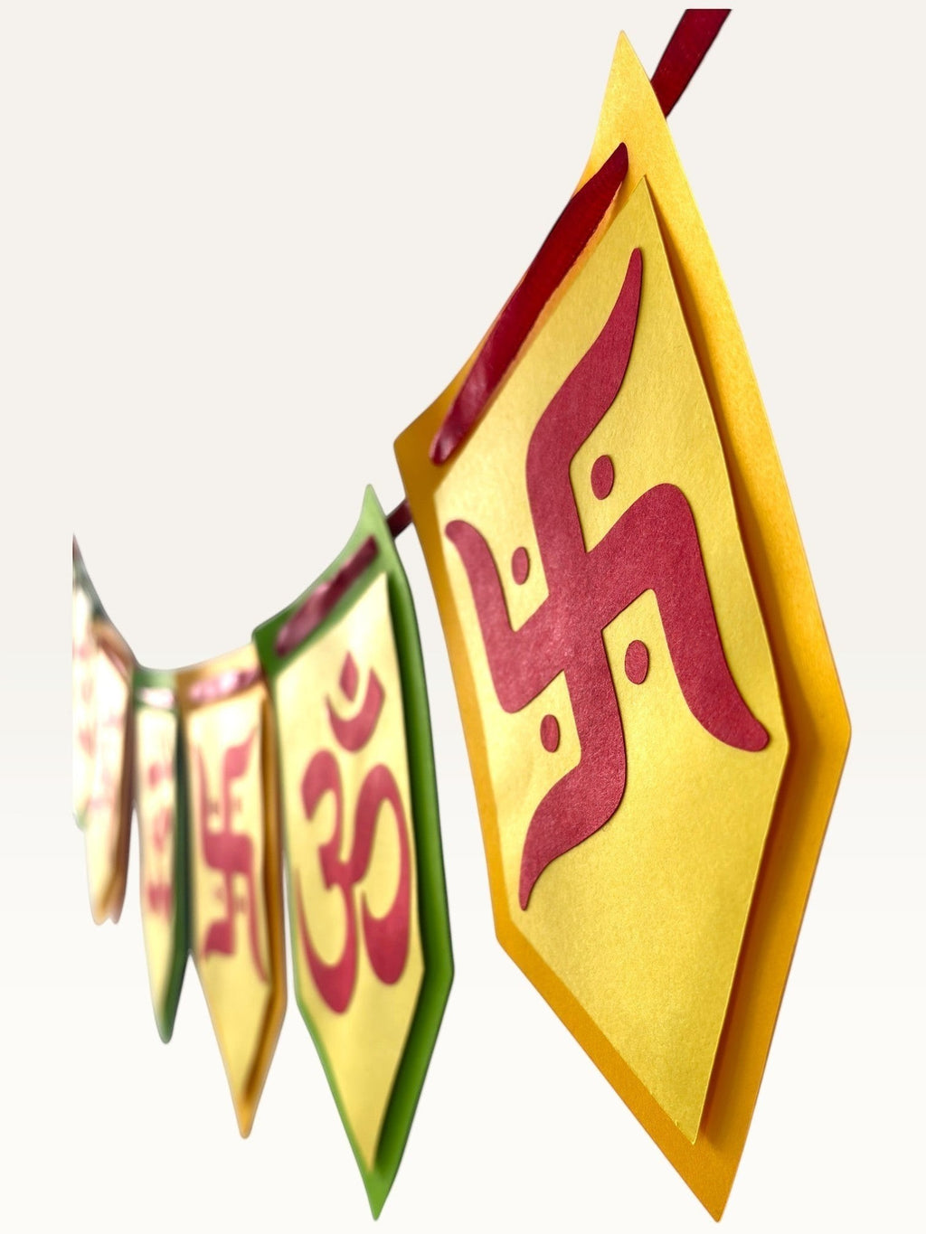 Paper Party Studio Om and Swastik bunting featuring vibrant pentagon-shaped paper flags for festive home decor.