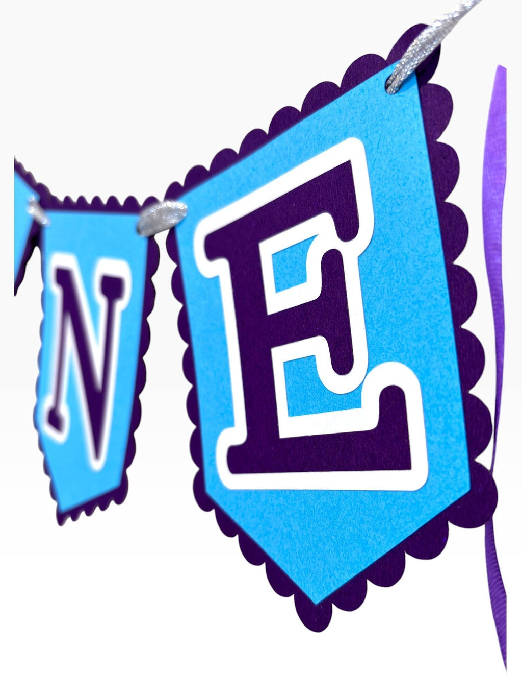 Paper Party Studio blue scalloped ONE banner for first birthday cake smash photos. Cardstock flags with purple letters.
