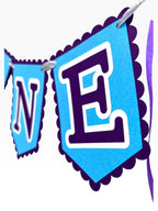 Paper Party Studio blue scalloped ONE banner for first birthday cake smash photos. Cardstock flags with purple letters.