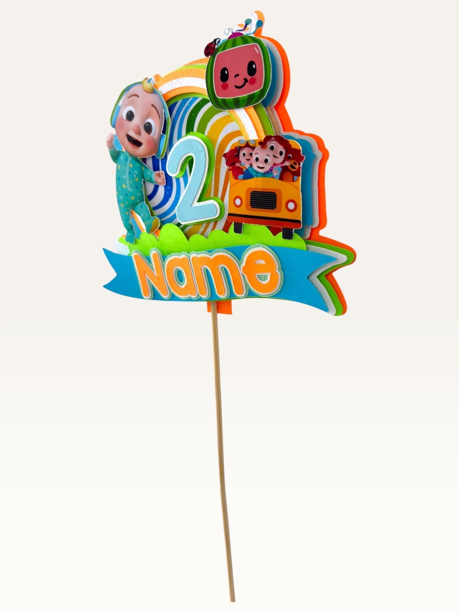 Paper Party Studio personalised sing-along birthday cake topper with layered cardstock rainbow and bus characters.